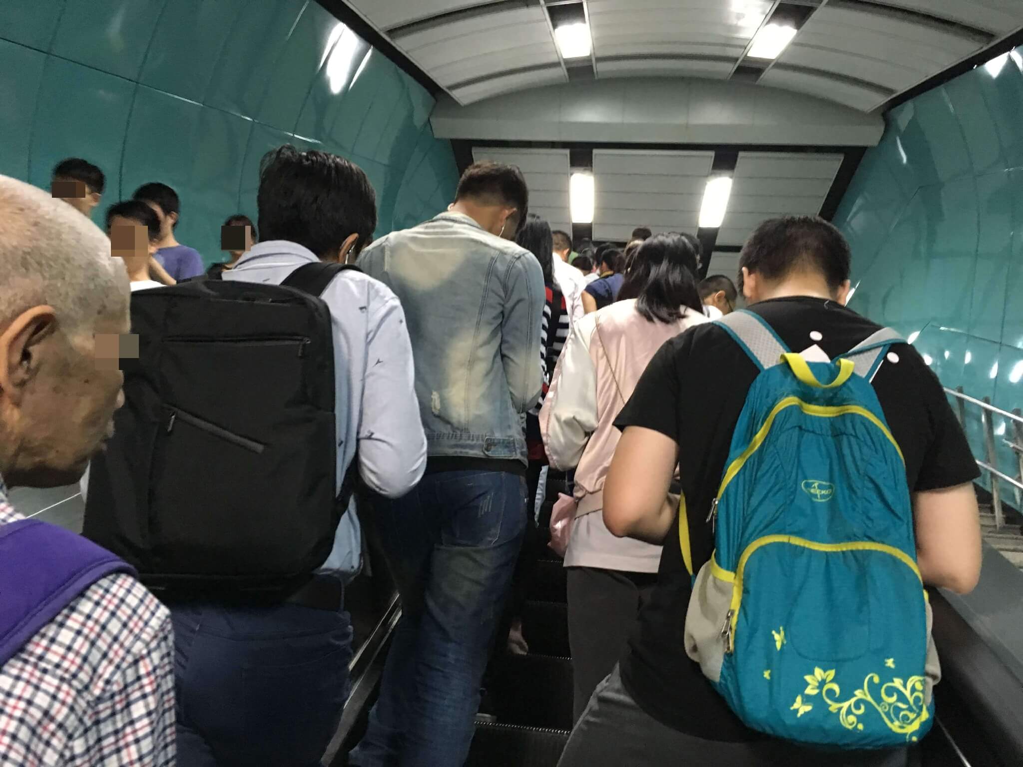 中国の駅構内で、人が大勢いる写真。